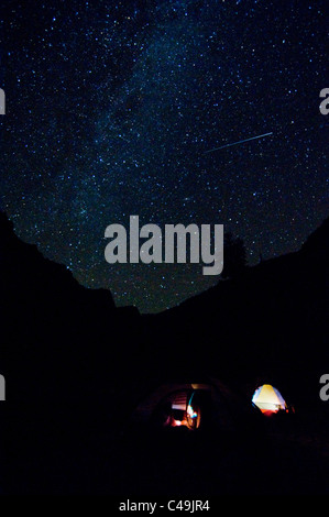 Meteor and Milky Way above two tents at Cliffside Camp on the Middle Fork of the Salmon River ID Stock Photo