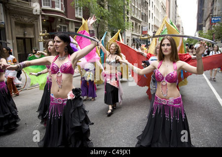 Anuual New York City Dance Parade along Broadway in New York City. Belly dancers balance swords on their heads as they dance. Stock Photo