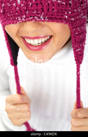 Vertical image of playful woman in knitted winter cap smiling