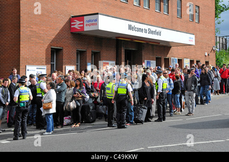 British Transport Police controlling crowds outside railway station waiting for buses after train cancellations & signal failure Stock Photo