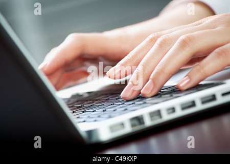 Image of human hands pressing keys of laptop Stock Photo