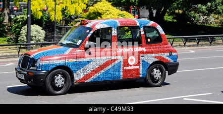 Close up view black Taxi cab temporary covered unusual Vodafone London Calling Union Jack flag & text tag word cloud advertising graphic England UK Stock Photo