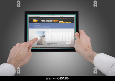 a male hand holding a touchpad pc, one finger touches the screen and surfing the web Stock Photo