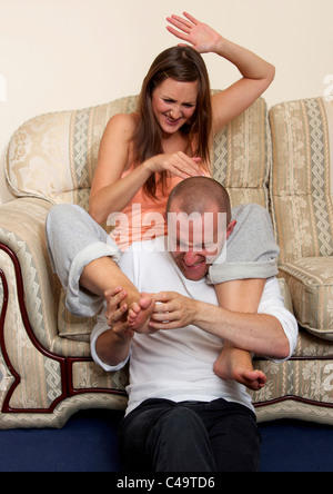 Man tickling woman's foot Stock Photo