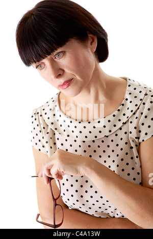 Portrait of middle aged female holding eyeglasses over white background Stock Photo