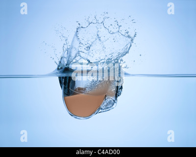 A cup of tea dropped in some water Stock Photo