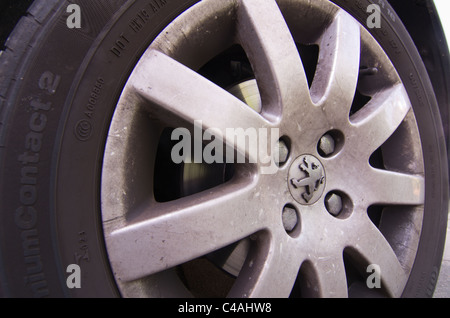 damaged dirty alloy wheel on Peugeot car Stock Photo