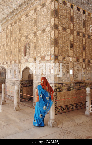 An Indian woman at the Jai Mandir Mirrorred Hall at the Amber Fort, Jaipur, India Stock Photo