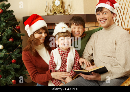 Portrait of happy family members standing next to each other and laughing while looking at camera Stock Photo