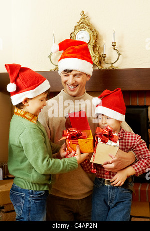 Portrait of happy boys and their father holding giftboxes Stock Photo