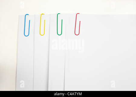 paper clip in four different colors - Blue, Green, yellow, red, keep the white together Sheets Paper Stock Photo