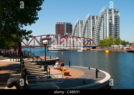 City Lofts and NV apartments over Erie Basin, Salford Quays, with part of  'Erie's Rest' in the foreground, a sculpture by Ingrid Hu, Salford, UK Stock Photo