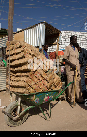 money changers carry loads of low value notes in wheelbarrows on the street, Barao, Somaliland, Somalia