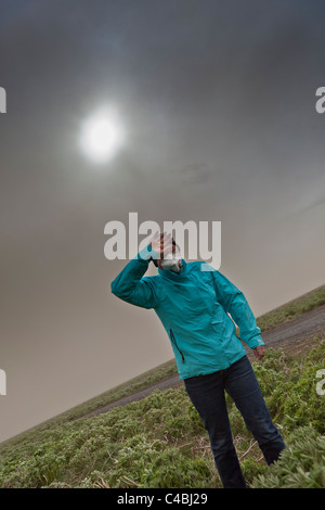 Woman wipes the ash from her eyes from Grimsvotn Volcanic Eruption in the Vatnajokull Glacier, Iceland Stock Photo