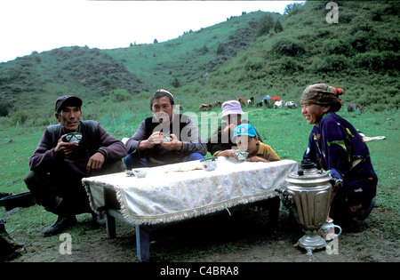 Kyrgyz family drinking tea in front of the yurt. Stock Photo