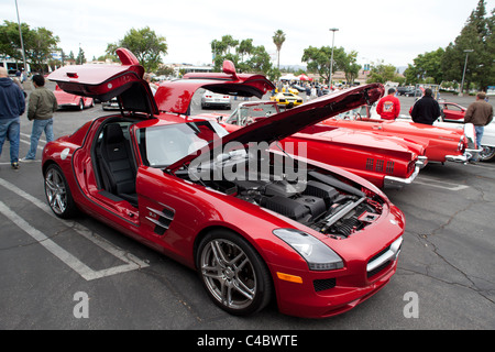 An AMG SLS supercar flanked by two old Fords Stock Photo