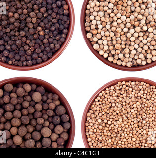 Ceramic bowls ful of pepper, coriander, cardamon, allspice isolated on white Stock Photo