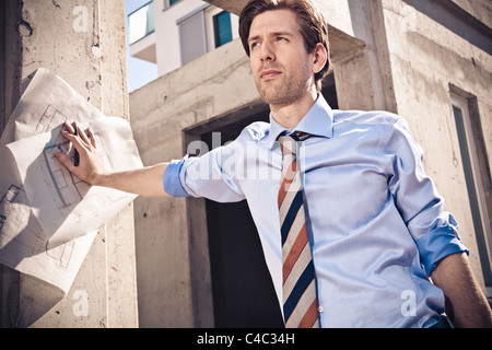 Businessman with blueprints on site Stock Photo