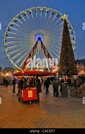 A portrait image showing a Christmas Tree,a big wheel,traders,and Christmas festivities in Lille Market France Stock Photo