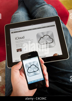 iCloud cloud computing service icon on an iPhone 4G smart phone screen with Apple website on iPad Stock Photo
