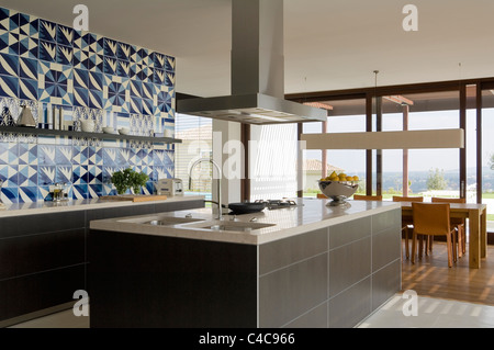 view across modern Bulthaup kitchen with bihara stone worktop on to eating area Stock Photo