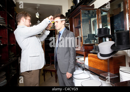 Customer being measured for Silk Top Hat at Lock & Co hatters, St James's Street, London. Photo:Jeff Gilbert Stock Photo