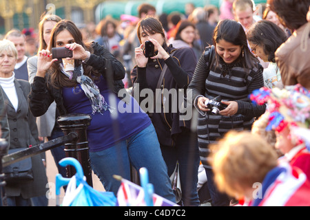 Tourists taking pictures on the Mall the evening before the royal wedding of Prince William and Kate Middleton Stock Photo