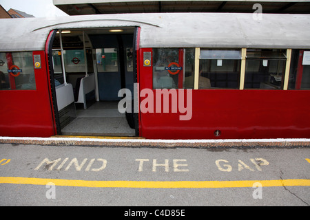 Old London Underground train used on the Isle of Wight Railway and mind the gap sign on the platform in the Isle of Wight Stock Photo