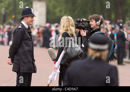 Policeman being interviewed on the street before the royal wedding of Prince William and Kate Middleton, April 29, 2011, London Stock Photo