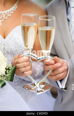Bride and groom holding wedding heart-shaped glasses with champagne Stock Photo