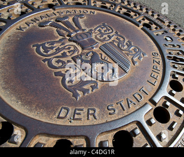 Cast iron manhole / sewer / drain cover in a Leipzig street. Stock Photo