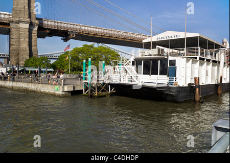 Bargemusic classical music venue former coffee barge moored at Fulton Ferry landing next to section Brooklyn bridge under repair Stock Photo