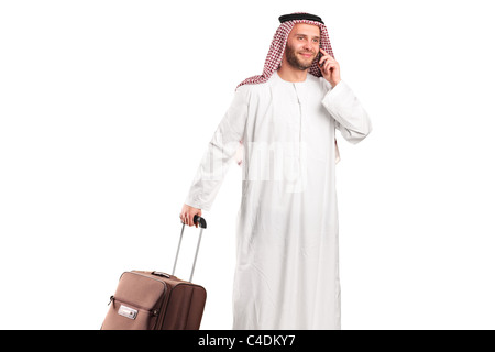 Arab tourist carrying a suitcase and talking on a mobile phone Stock Photo