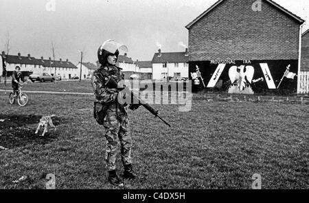 A dog barks at a soldier from The Queens Regiment while patroling the streets of Belfast , Northern Ireland in April 1984 . Stock Photo