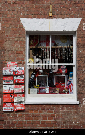 The colourful window display of the fancy dress and novelty goods shop, “Instant ReDress”. Bridport, Dorset, England, United Kingdom. Stock Photo