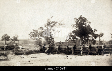 Civil War soldiers in action with soldiers firing rifles from behind barrier. Stock Photo