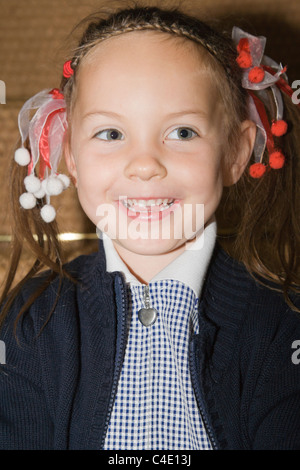 4 years old schoolgirl in gingham dress, summer school uniform Stock Photo