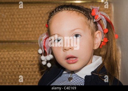 4 years old schoolgirl in gingham dress, summer school uniform Stock Photo