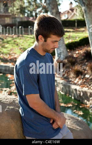 Young man meditating prayerful and thoughtful alone in park.nature, natural surroundings,  MR © Myrleen Pearson Stock Photo