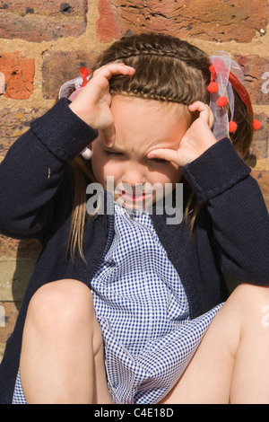 4 years old schoolgirl in gingham dress, summer school uniform Stock Photo