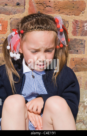 4 years old schoolgirl in gingham dress, summer school uniform Stock Photo