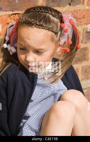 4 years old schoolgirl in gingham dress, summer school uniform Stock Photo