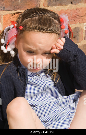 4 years old schoolgirl in gingham dress, summer school uniform Stock Photo