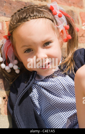 4 years old schoolgirl in gingham dress, summer school uniform Stock Photo