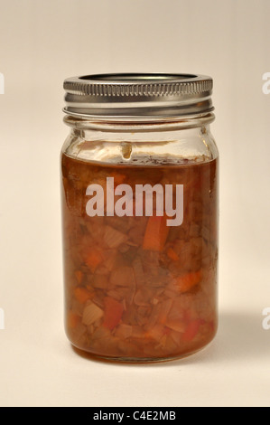 A jar of home made relish sits on a white background Stock Photo