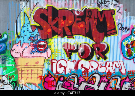 A graffiti mural painted on corrugated steel depicting a screaming ice cream cone Stock Photo