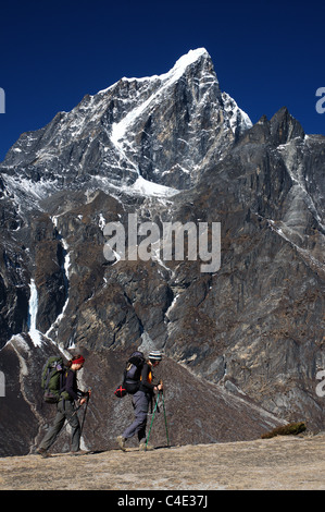 Two female trekkers pass in front of Taboche peak in Nepal Stock Photo