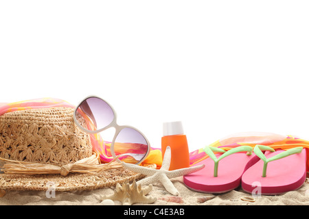 Beach accessories with straw hat,sun glasses,shawl and flip flops on sand. Stock Photo