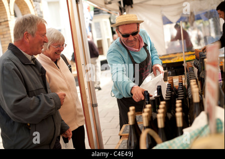 Two People  - couple husband and wife -  shopping for french wine at a continental street market, Aberystwyth Wa;es UK Stock Photo