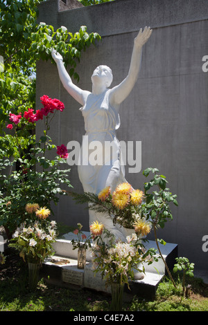 White sculpture of a woman among flowers at Santiago's General Cemetery in Recoleta. Stock Photo